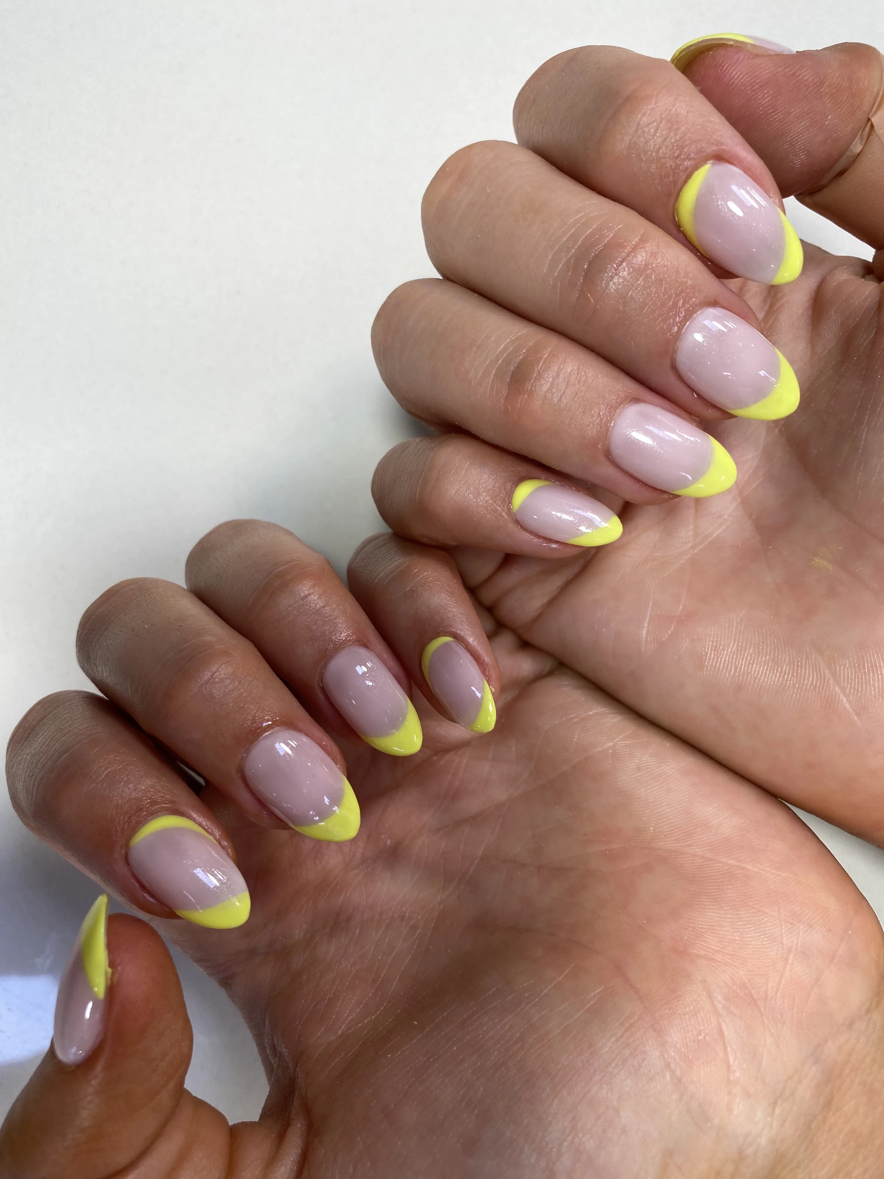 Soft-pink base with bright yellow French-tip almond nails