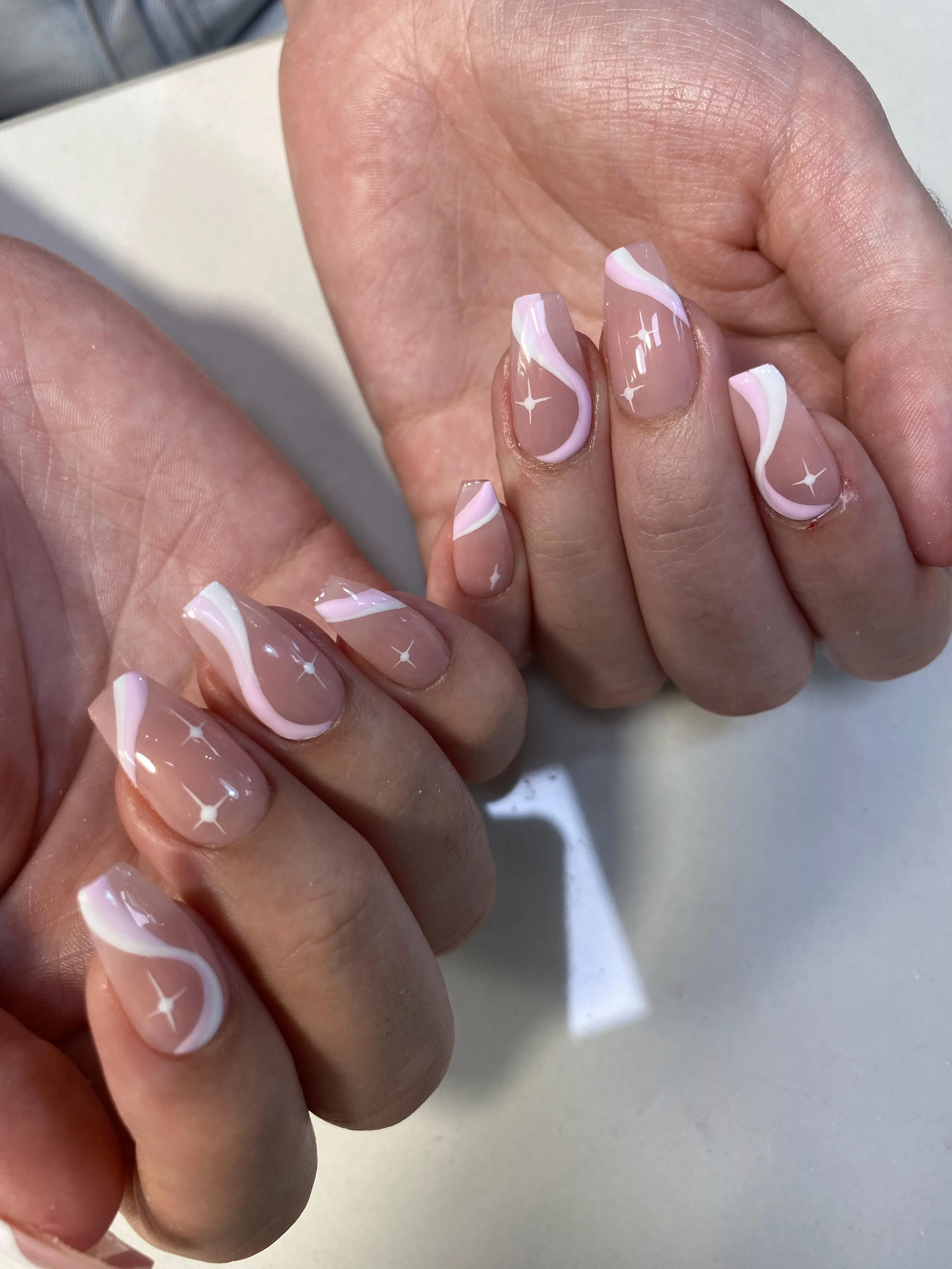 Nude nails with pink swirl French and white sparkle stars