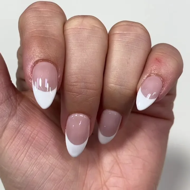 Clean white-tip almond nails on one hand, white ground
